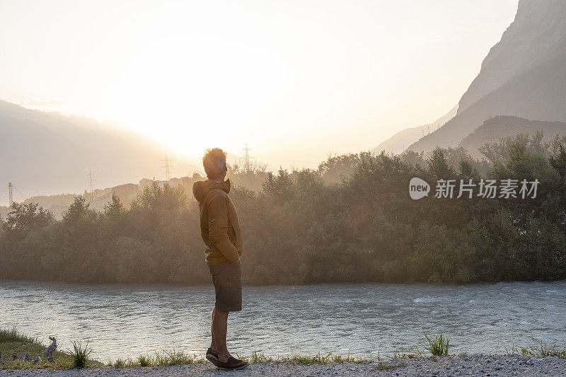 日出时，一名男子在河边休息