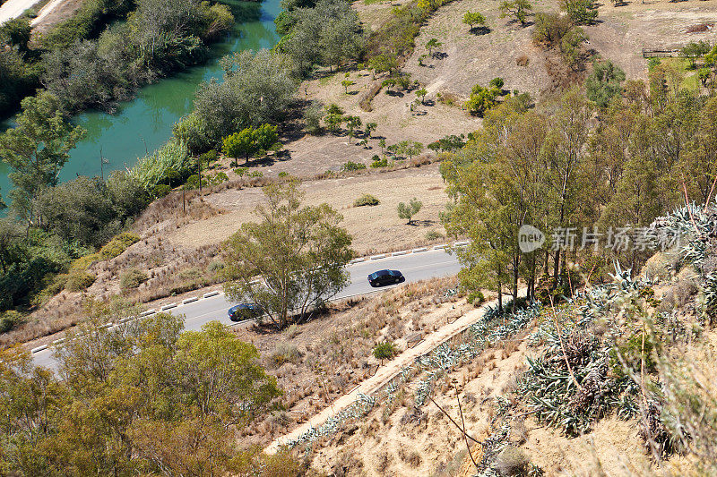 汽车行驶在乡村道路上，从上面俯瞰，乡村，河流，树木和田野，西班牙
