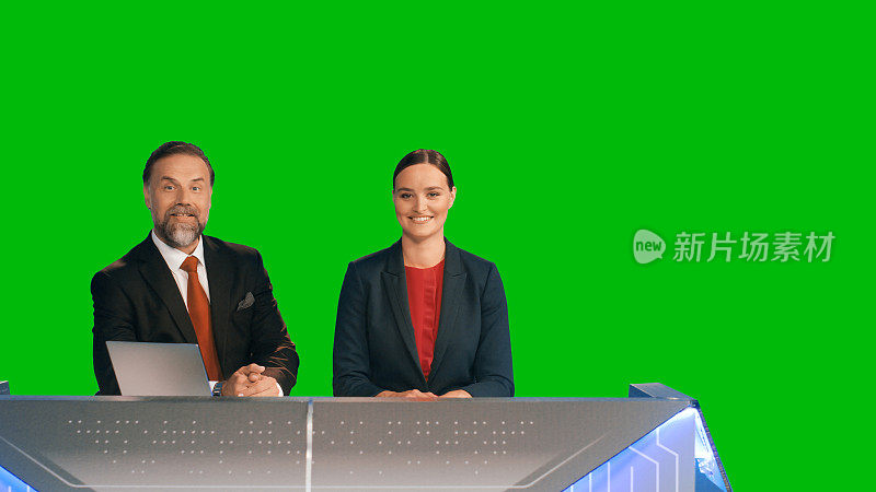 绿幕背景:现场新闻演播室，美丽的女性和英俊的男性主播报道当天的事件。电视频道新闻编辑室概念。色度键模板背景