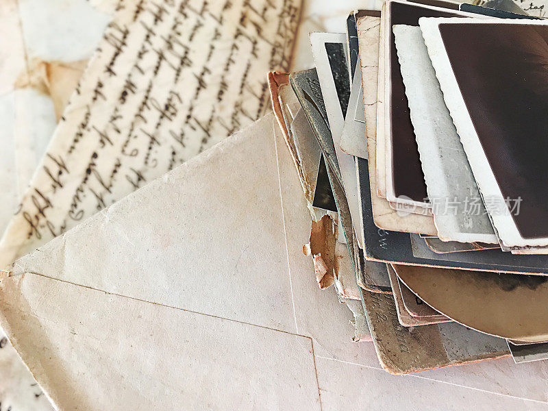 在散落的旧信件和明信片中，用铅笔在一本古老的日记本上画风景画