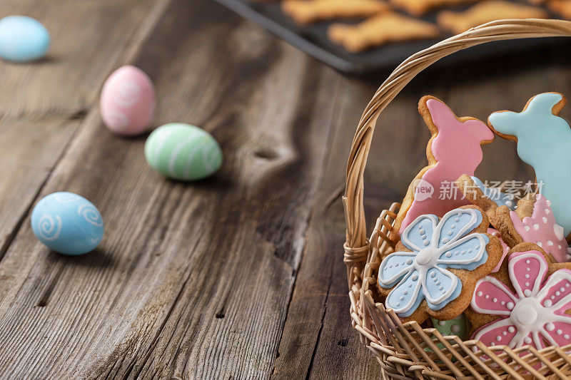 木桌上放着自制的复活节姜饼曲奇，形状是复活节兔子和鲜花。