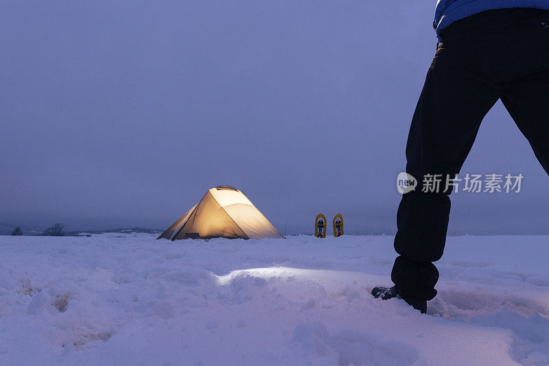 成熟的旅游帐篷露营，夜间在冬季的高山大自然中独自露营。