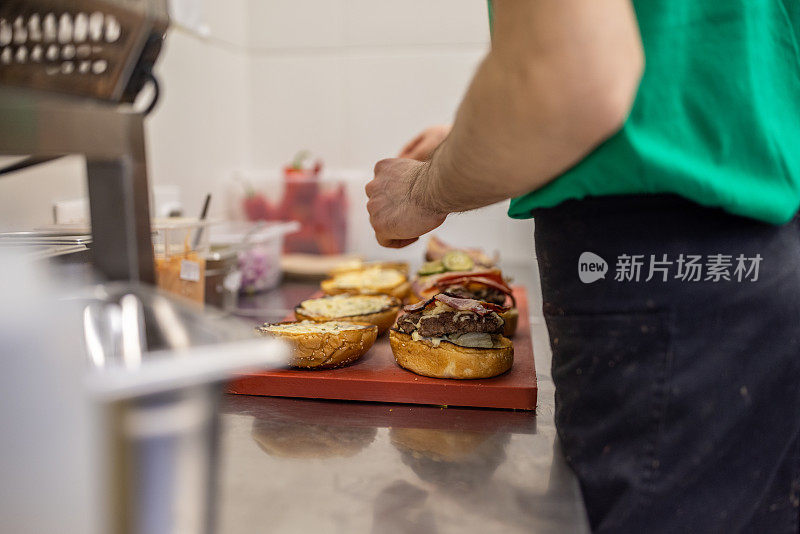 一个面目全非的厨师，在快餐店的厨房里做汉堡