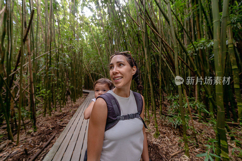 带着蹒跚学步的女儿在大自然远足的女人