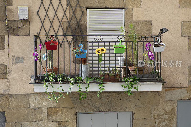 在关闭的百叶窗外的阳台上种植植物和装饰品