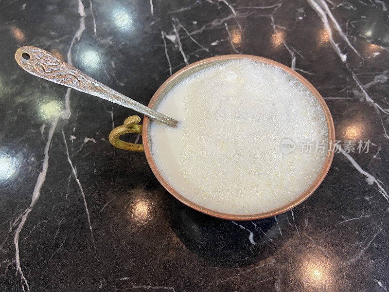 把酪乳放在传统的碗里，桌上放上勺子
