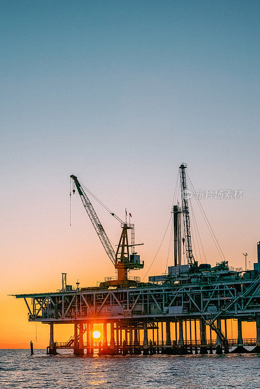 在亨廷顿海滩海岸的海上石油钻井平台后面的美丽日落