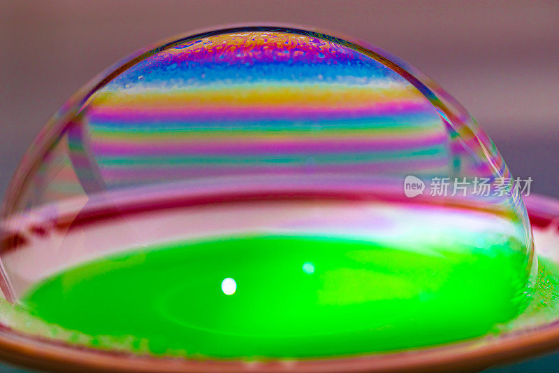 鲜艳的彩虹色宏观肥皂泡创造迷幻的图案，在光圆顶洗涤店和洗涤剂泡沫