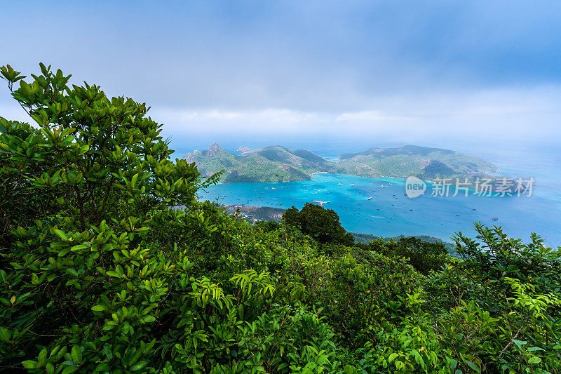 越南孔岛的本坝港，有美丽的碧海蓝天山和五颜六色的小船。