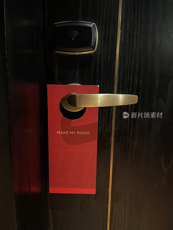 关闭的木质图像，酒店房间的门上挂着“让我的房间”的标志，红色的要求女佣清洁服务的标志，木纹背景，重点在前景