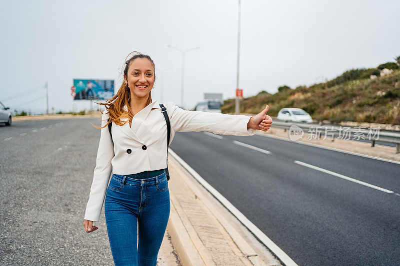 在马耳他的高速公路上搭便车的年轻女子