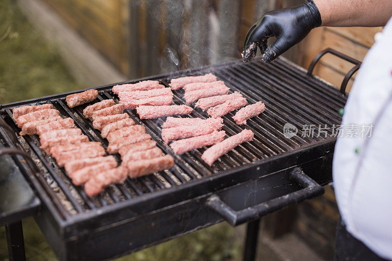 厨师在烤架上整理肉