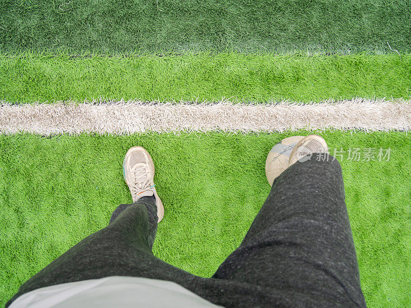 足球运动员踩着球站在足球场上