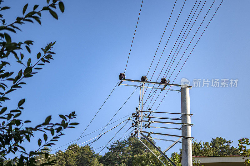 乡村风景中的高压塔上悬挂着粗大的电力电缆