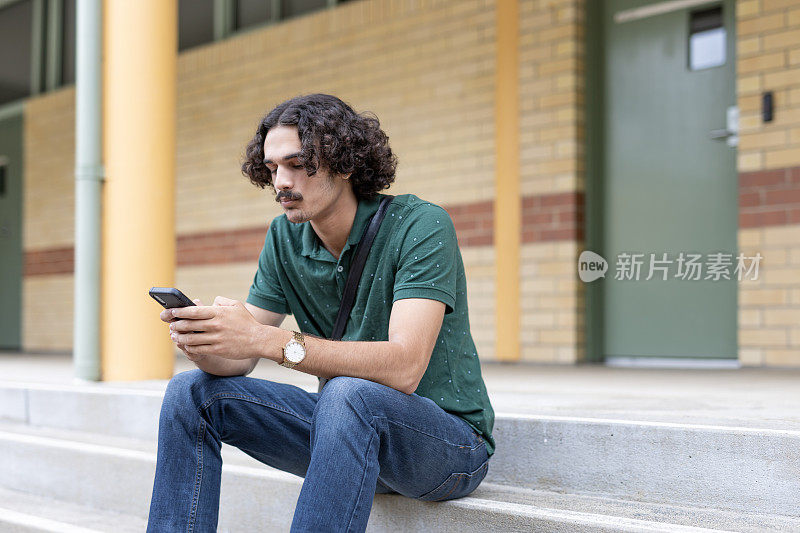 年轻的多种族男子在户外使用手机