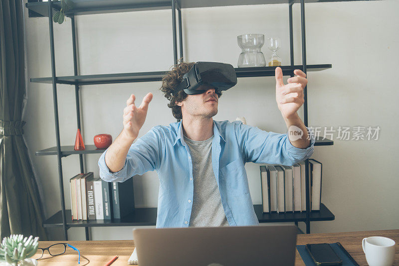 创意设计师兴奋地看着VR眼镜头显。拥有虚拟现实体验的人。玩电子游戏或模拟世界时触摸空气
