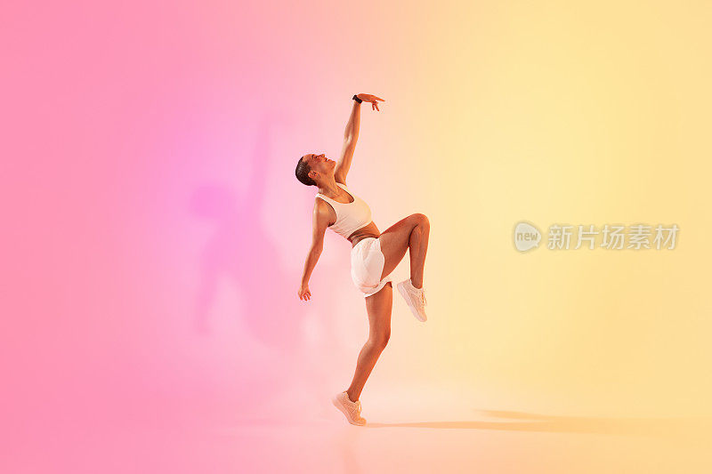 一位精力充沛的年轻舞者摆出动感的姿势，捕捉到了动作和优雅的精髓