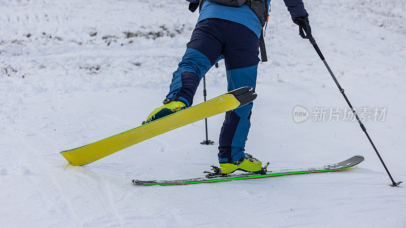 一个人在滑雪或登山时进行180度转弯的步法细节。一个人在滑雪板上转弯向山上走。步骤3