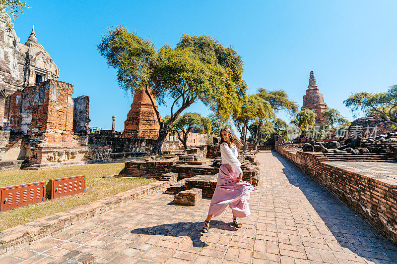 年轻女子在泰国大城府历史公园的Ratchaburana寺转圈