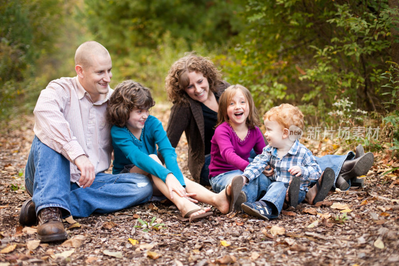 幸福家庭与父亲，母亲，女儿和儿子在森林