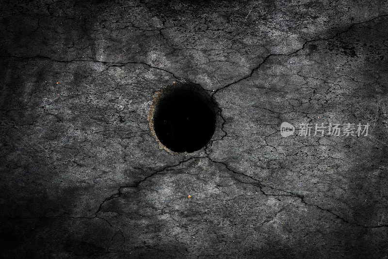 有裂缝的地板上有黑洞，水泥陈旧