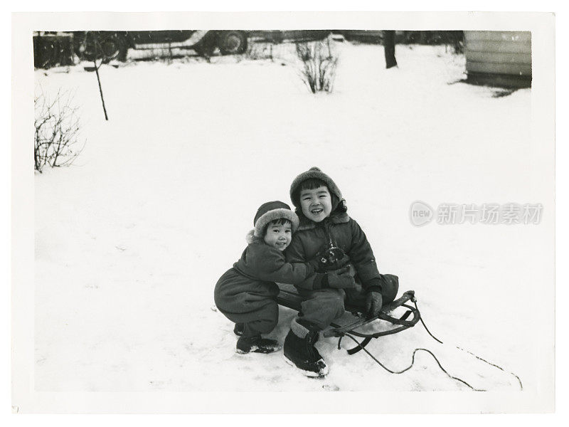 两个亚洲孩子在雪中玩耍