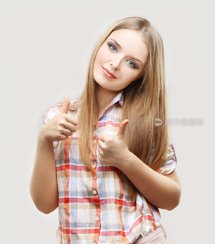 少女对着镜头微笑，竖起大拇指。