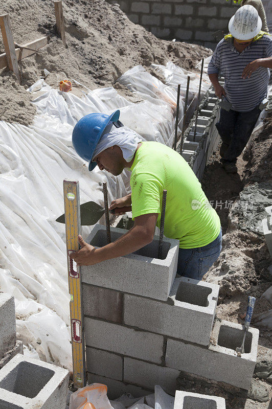 西班牙建筑工人正在建造煤渣砖墙