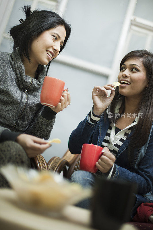 不同种族的快乐女性朋友喜欢喝咖啡吃零食。