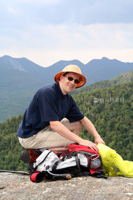 在山顶上背着背包的男子徒步旅行者