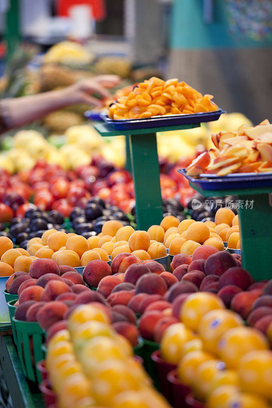 市场上一排五颜六色、不同种类的水果。