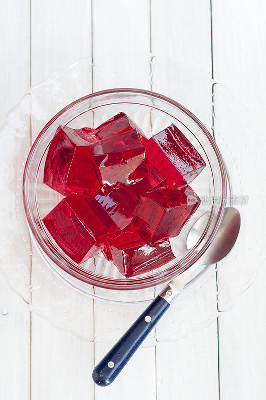 白色背景的玻璃碗里的红色果冻块