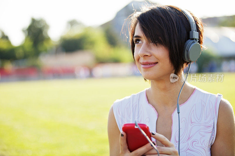 年轻女子在用智能手机听音乐