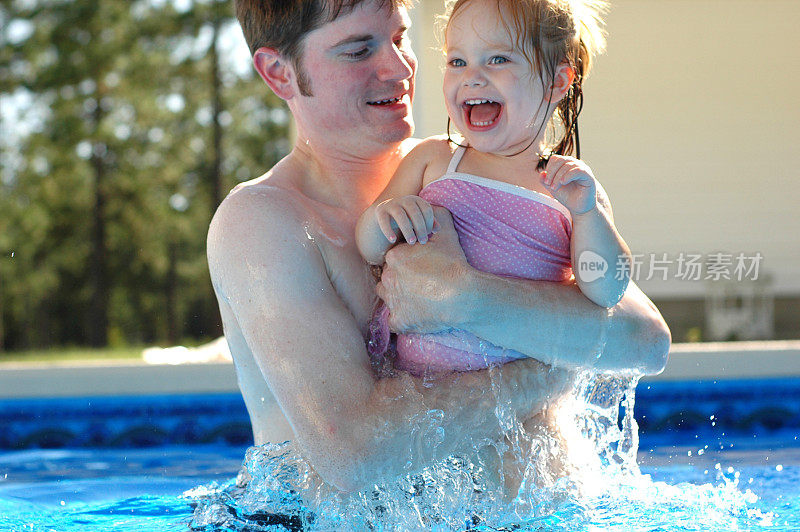 爸爸和女儿在游泳池里跳