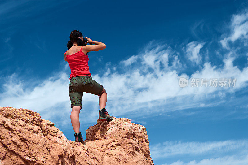 一个年轻女子正在用双筒望远镜看东西