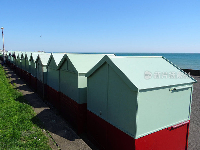 一排排的木制海滩小屋，漆成鸭蛋绿色