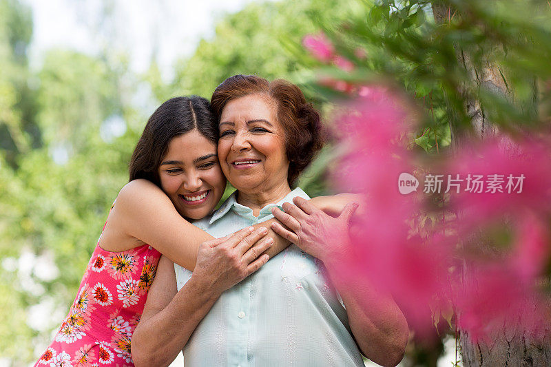 美丽的西班牙祖母和孙女拥抱在一起