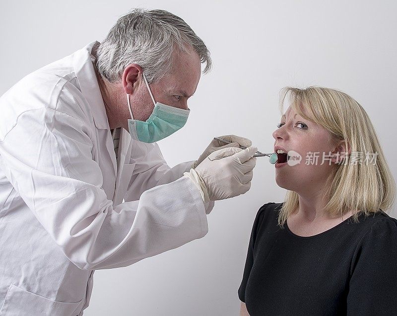 牙医正在检查一位女性病人的牙齿