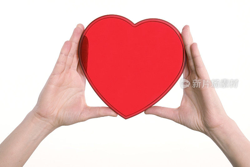 双手握着一个红色透明的心对白色的背景。
