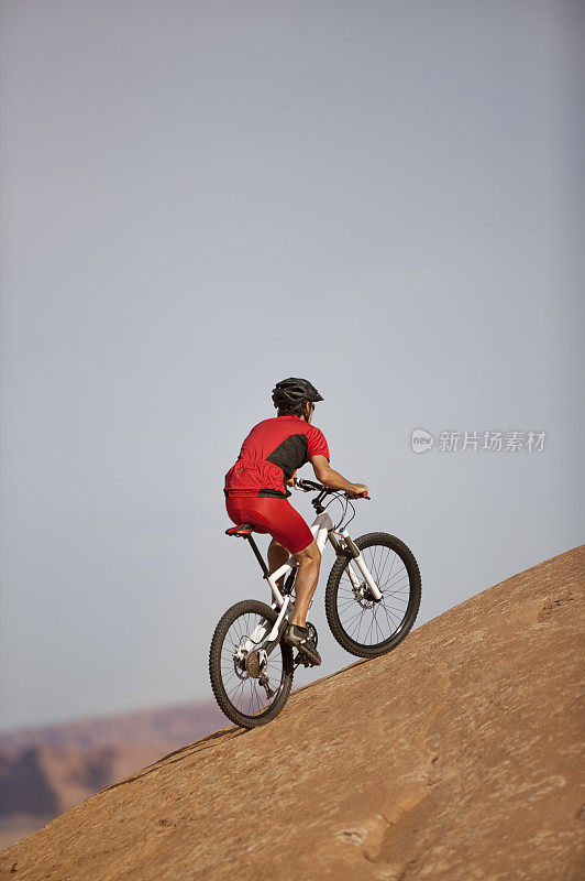 男性自行车骑在陡峭的山坡上滑石小径