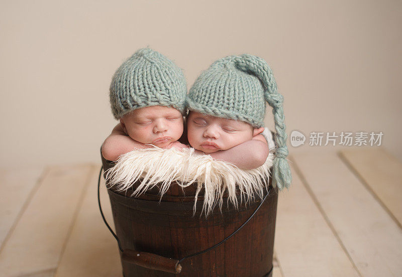 新生双胞胎睡在古董桶里