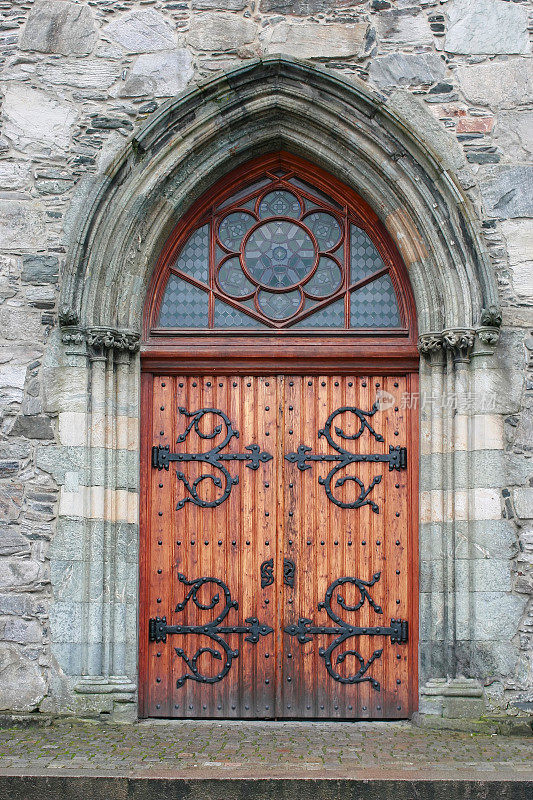 中世纪教堂门与石头拱门和彩色玻璃