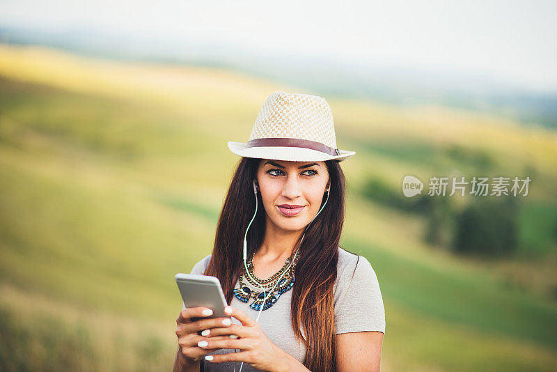 年轻女孩在大自然中聆听音乐