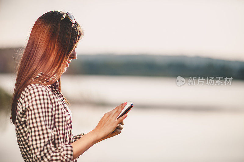 年轻女子在户外使用数码平板电脑