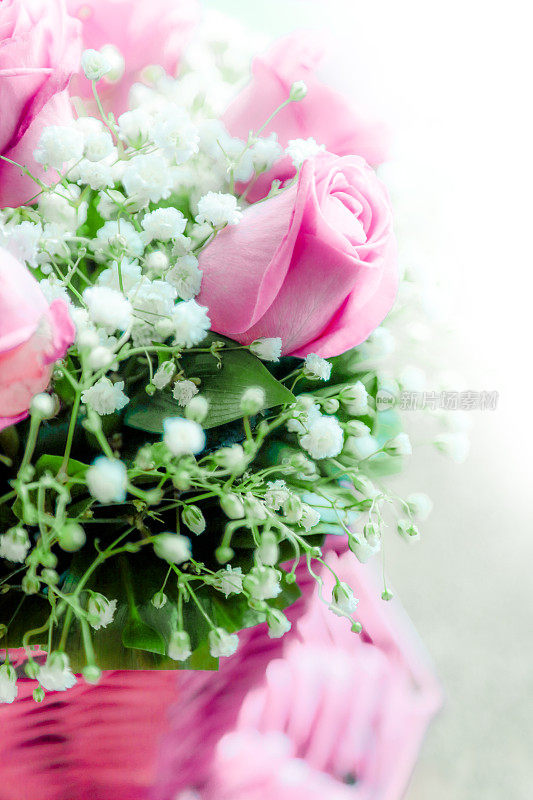 一束精致的粉红色玫瑰和小白花