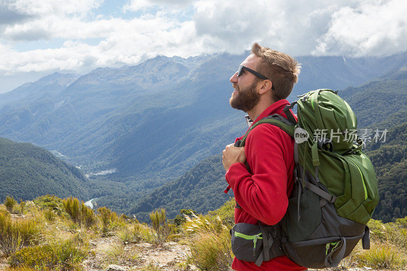 新西兰米尔福德湾，徒步旅行者在山顶欣赏风景