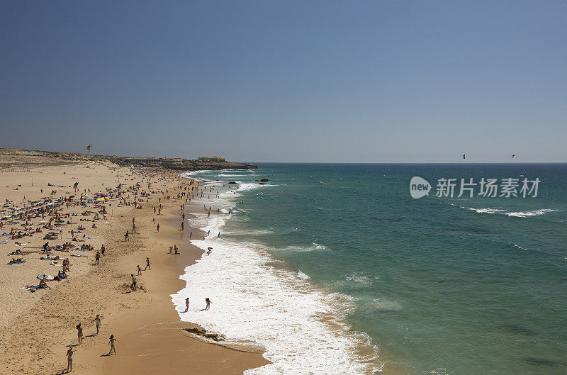 人们在金秋海滩晒日光浴、游泳和冲浪