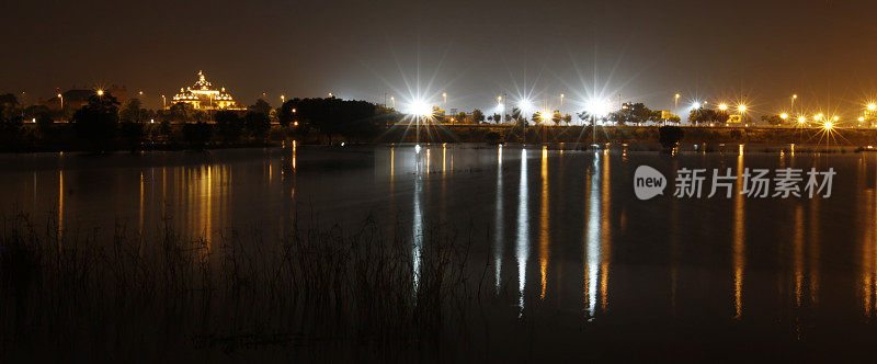 德里城的灯光映照在河上。