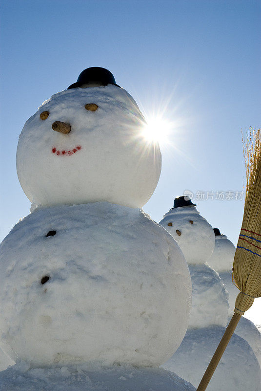 雪人军队-雪人戴着帽子和扫帚在太阳