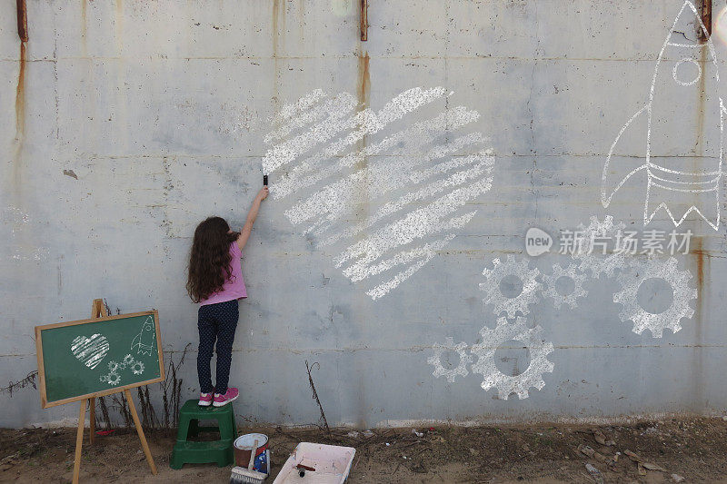 小女孩在墙上画画